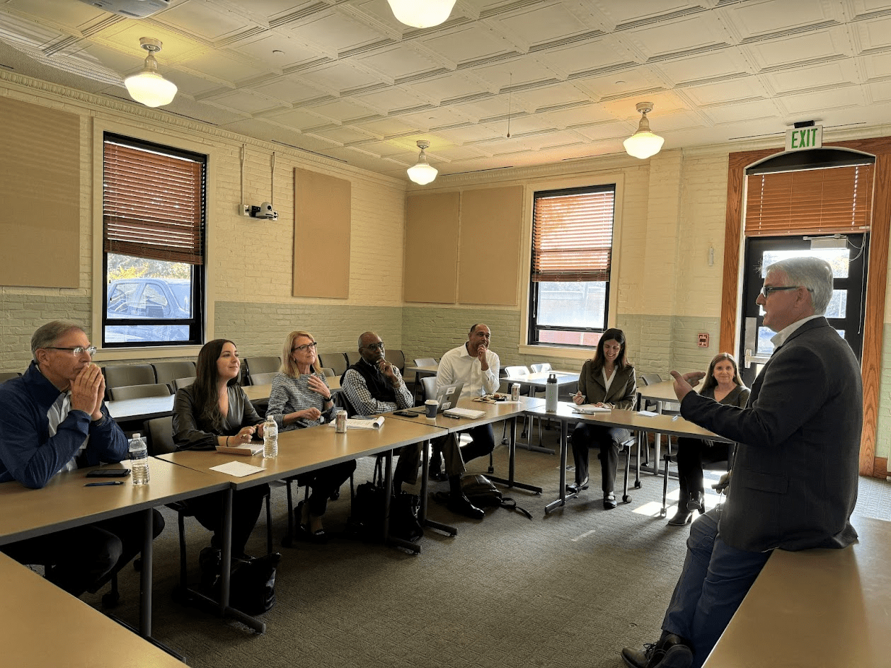 Men and women board members at their annual meeting and talk with department chair.