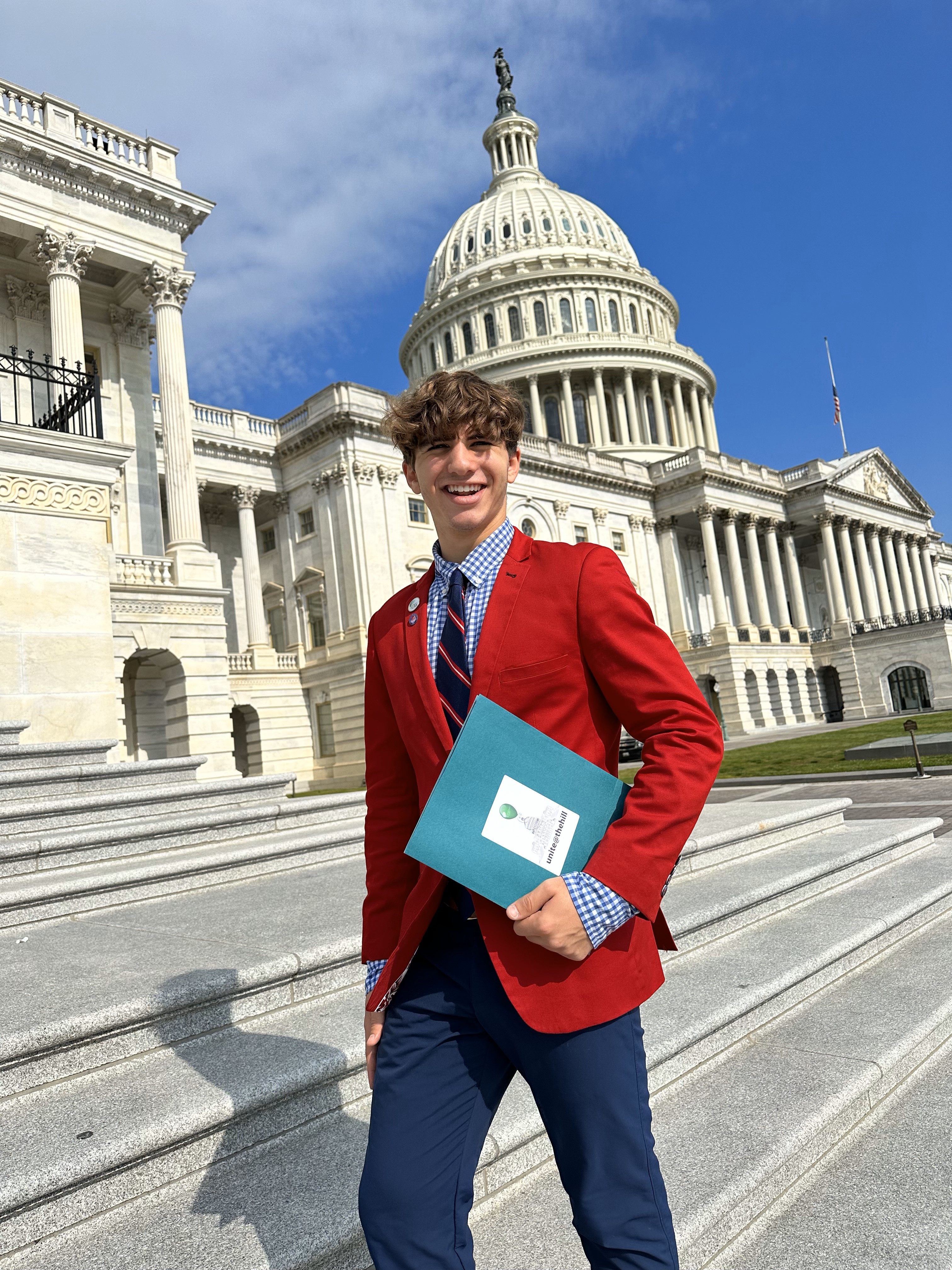 Noah Forman smiles in front of the U.S. Capitol building.